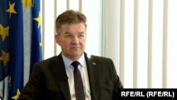 Miroslav Lajčák sitting in front of European union flag