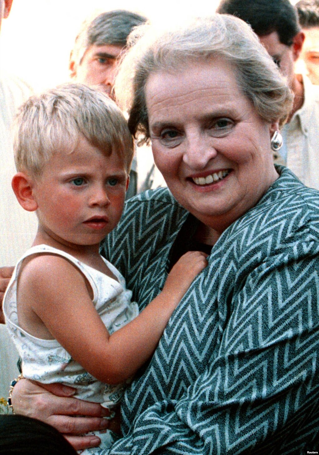 Ish-sekretarja amerikane e Shtetit, Madeleine Albright, duke mbajtur në duar një refugjatë kosovar gjatë vizitës së saj më 11 qershor 1999 në një kamp refugjatësh në Maqedoninë e Veriut. Albright kishte shkuar në Shkup vetëm pak kohë para se trupat e NATO-s të hynin në Kosovë.