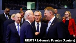 Klaus Iohannis (dreapta) la reuniunea NATO din 24 februarie. România a primit noi forțe militare ale SUA recent și va avea un grup de luptă NATO pe teritoriul său.