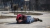 A mother shelters her son as shells impact the besieged southern port city of Mariupol on March 23.&nbsp;