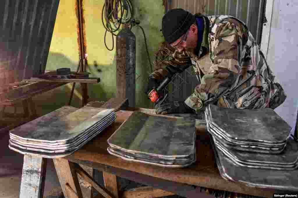 Egy önkéntes készíti a golyóálló mellényhez szükséges acéllemezeket Zaporizzsjában