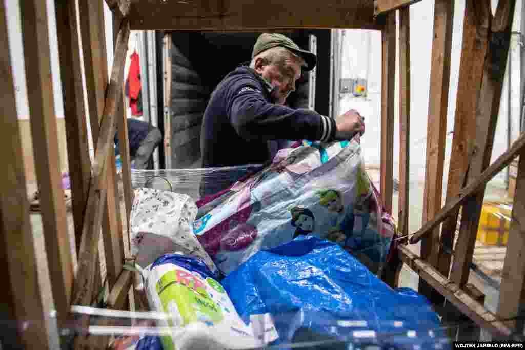 Önkéntes válogatja a lvivi raktárba beérkezett adományokat március 21-én