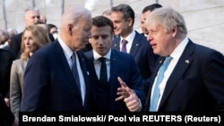 U.S. President Joe Biden (left) talks with French President Emmanuel Macron (center) and Britain's Prime Minister Boris Johnson ahead of an extraordinary NATO summit in Brussels on March 24.