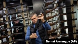 Ukraine -- A customer checks his rifle in a gun shop in Lviv