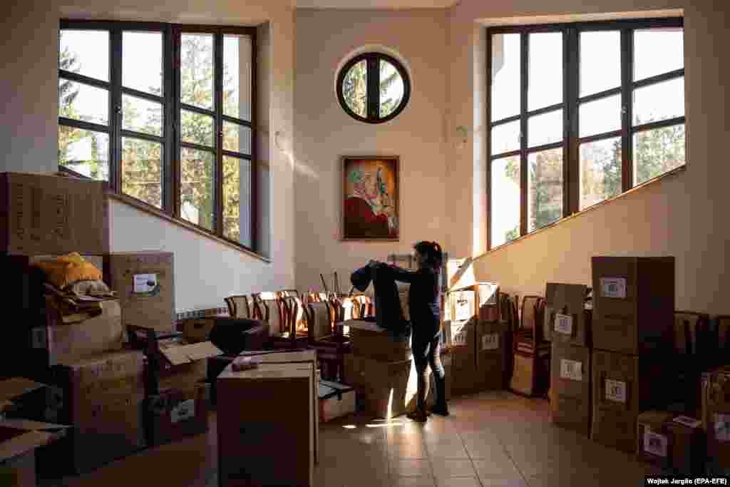 A volunteer sorts through boxes of humanitarian aid in Briukhovychi.