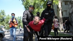 Полиция жасағы оппозицияның митингісі өтетін жерге келген азаматты әкетіп барады. Алматы, 6 маусым 2020 жыл.