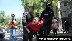 Полицейские несут задержанного в автозак. Алматы, 6 июня 2020 года.
