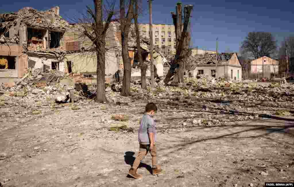 A child walks in front of a school damaged by shelling in the city of Zhytomyr in northern Ukraine.&nbsp;