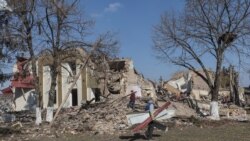 Localnicii curăță resturile din centrul cultural distrus în bombardamente la începutul acestei luni, în timp ce invazia Rusiei în Ucraina continuă, în satul Byshiv din afara Kievului, Ucraina, 24 martie 2022. REUTERS/Marko Djurica