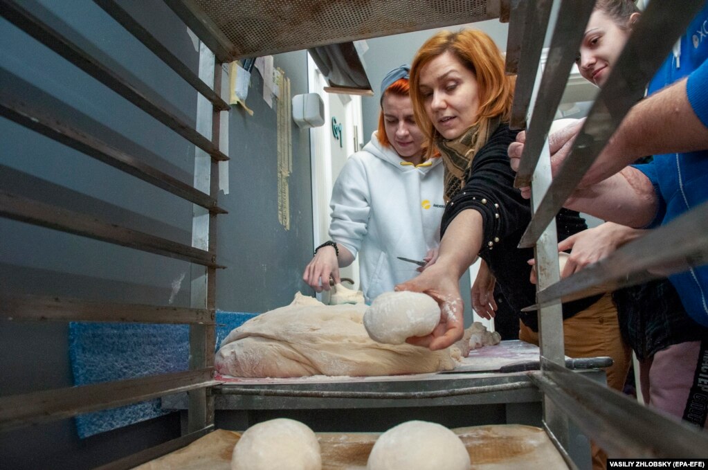 Vullnetarët pjekin bukë për ushtarakët në qytetin verilindor të Harkivit, 22 mars.