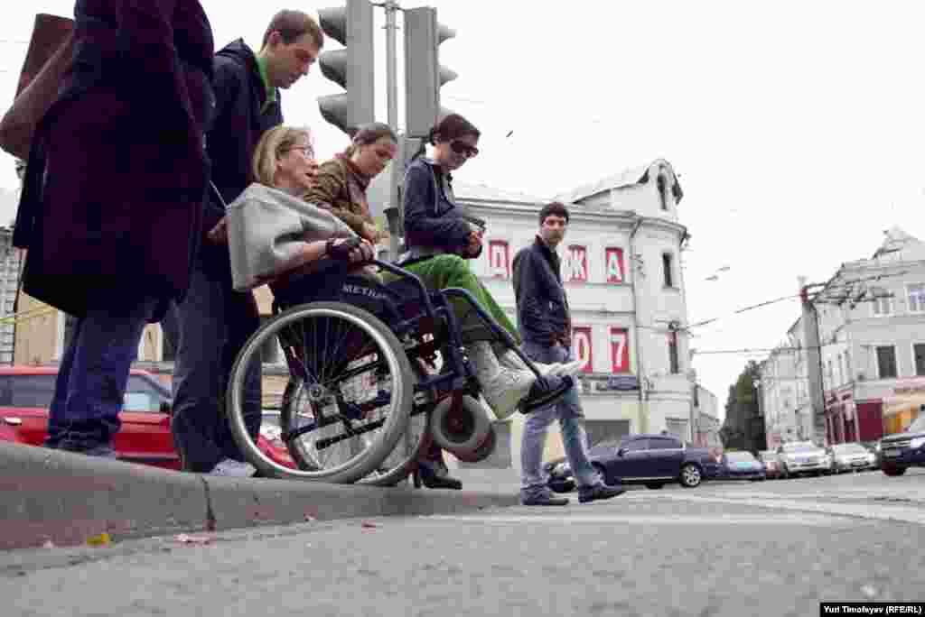 Несмотря на то, что бордюры у пешеходного перехода занижены, инвалид-колясочник не может преодолеть их без посторонней помощи