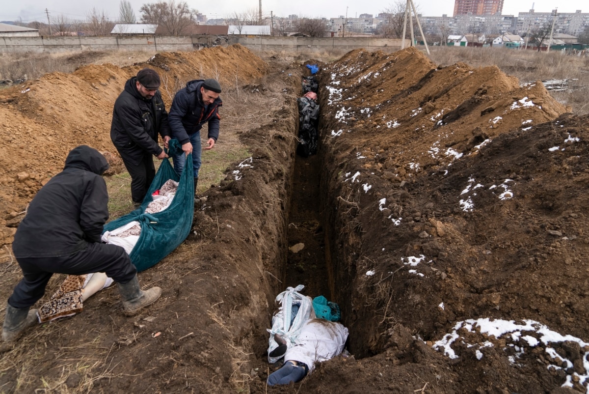 Тіла загиблих цивільних кладуть у братську могилу на околиці Маріуполя, оскільки люди не можуть поховати своїх загиблих через обстріл з боку російських військ. Маріуполь, 9 березня 2022 року