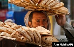 Egyiptomi utcai árus a hagyományos baladilepénnyel Kairó óvárosában. Az országban a kenyér sokkal fontosabb élelmiszer, mint sok más helyen; a kormány sokáig mesterségesen alacsonyan tartotta az árát