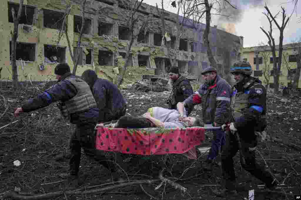 A wounded, heavily pregnant woman is carried on a stretcher from a Mariupol maternity hospital that was hit by an apparent missile explosion on March 9. Both the woman and the baby later died.