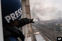Фотограф Associated Press Євген Малолєтка показує на дим, що піднімається після авіаудару по пологовому будинку, Маріуполь, 9 березня 2022 року