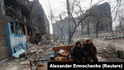 Жительницы Мариуполя во дворе разрушенного обстрелами дома, Украина, 25 марта 2022 года. Фото: Reuters