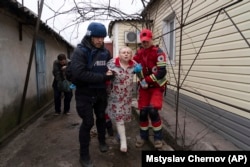 Евгений Малолетка и парамедик помогают раненой женщине. Мариуполь, 2 марта 2022 года. Фото Мстислава Чернова