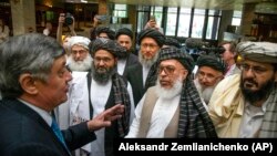 Russian presidential envoy to Afghanistan Zamir Kabulov (left) speaks to Mullah Abdul Ghani Baradar, the Taliban group's top political leader (third left) and other members of the Taliban in Moscow in 2019.