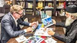 Mitropolitul Antonie al Basarabiei îi arată schițele pentru construcția unor biserici ambasadorului Cristian-Leon Țurcanu, la o vizită pe care oficialul român a făcut-o la Bălți pe 5 august 2026. 