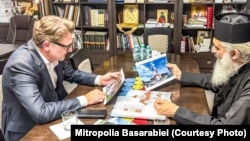 Mitropolitul Antonie al Basarabiei îi arată schițele pentru construcția unor biserici ambasadorului Cristian-Leon Țurcanu, la o vizită pe care oficialul român a făcut-o la Bălți pe 5 august 2026. 