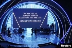 Плакат с призывом поддержать Украину во время церемонии награждения "Оскарами", 27 марта 2022 года