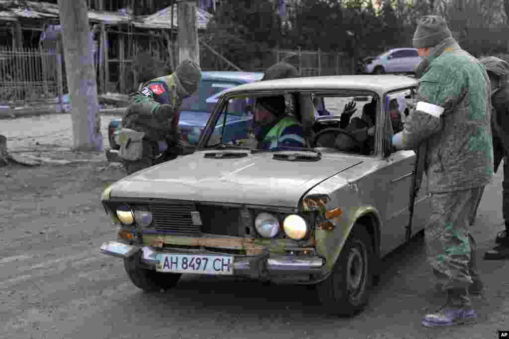 A donyecki szakadár erők katonái ellenőriznek egy járművet Mariupol külvárosában március 27-én