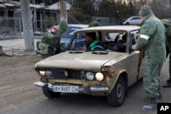 Бойци от самопровъзгласилата се Донецка народна република проверяват кола в покрайнините на Мариупол, контролирани от сепаратистите, 27 март 2022 г.