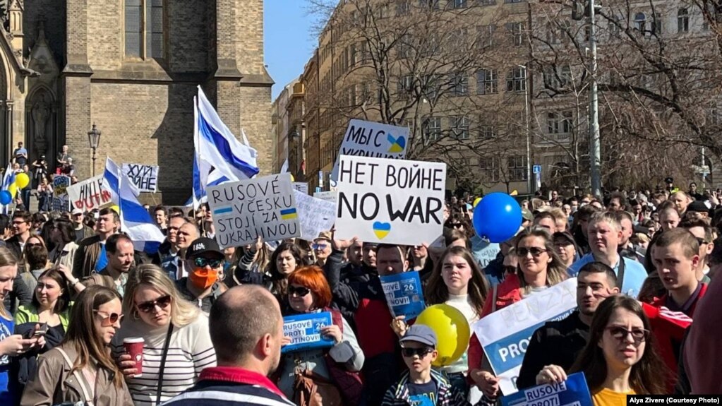 Люди тримали плакати з написами «Ні війні», «Росіяни проти Путіна», «Путін – це війна» російською, чеською та англійською мовами