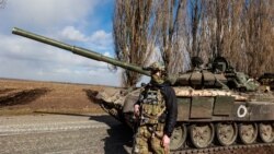 Украинский военнослужащий у захваченного российского танка Т-72. Март 2022 года, Киевская область