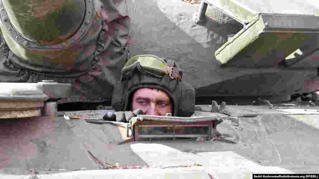 A Ukrainian soldier drives a Russian tank.