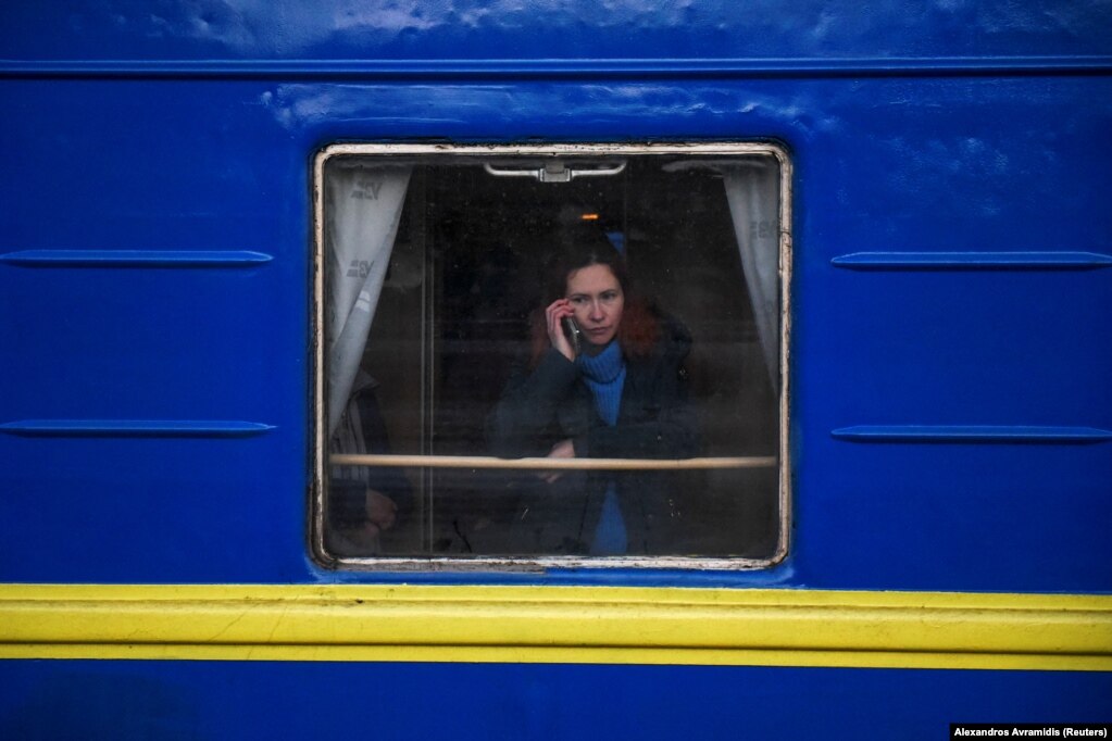 Një grua duke folur në telefon, teksa shikonte nga dritarja e një treni me civilë që largoheshin nga lufta. (Odesë, 9 mars)