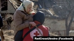 Ілюстраційне фото: волонтер Товариства Червоного Хреста України допомагає з евакуацією із зони бойових дій