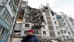 Valentina Demura, în vârstă de 70 de ani, lângă clădirea în care se află apartamentul ei din Mariupol, distrus de bombardamentele rușilor, 27 martie 2022