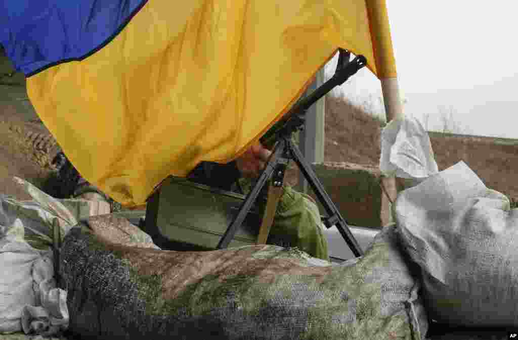 Egy géppuska és az ukrán zászló Harkiv közelében a frontvonalon március 26-án