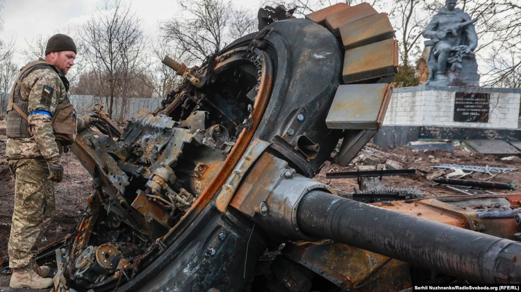 A Ukrainian servicemember inspects the remains of a destroyed Russian tank in the village of Lukyanivka, near Kyiv, on March 27.