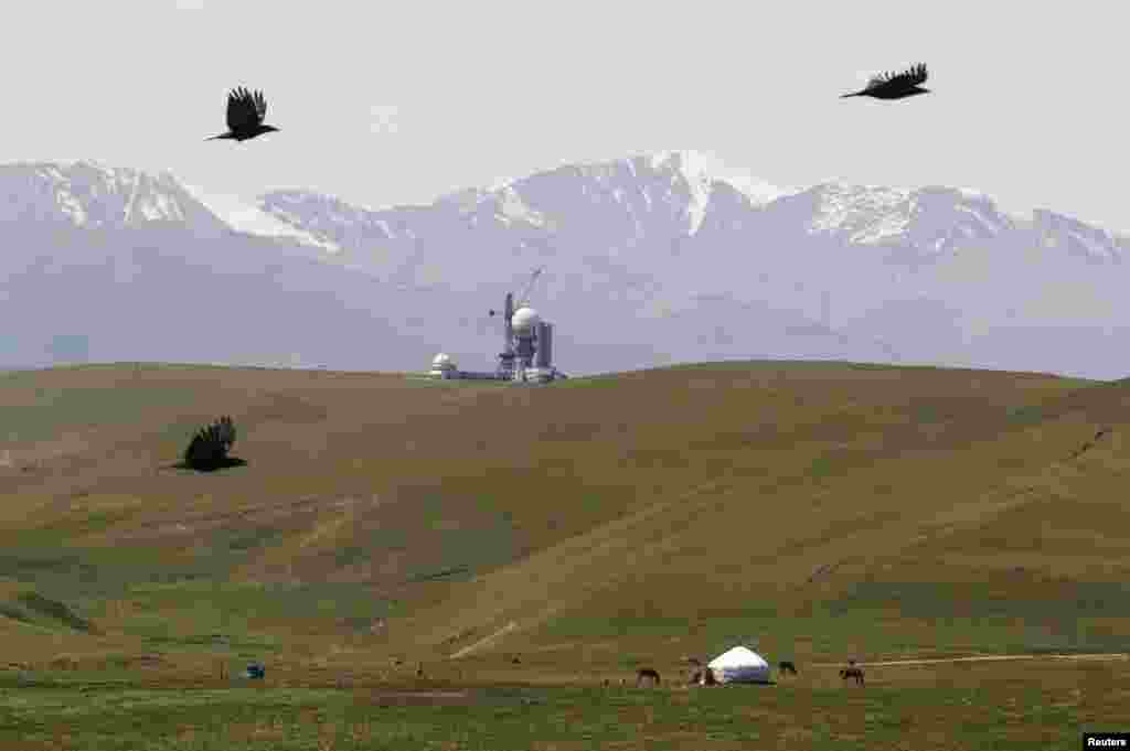 A farmer's yurt, or traditional nomad felt tent, is seen in front of a Soviet-era observatory
