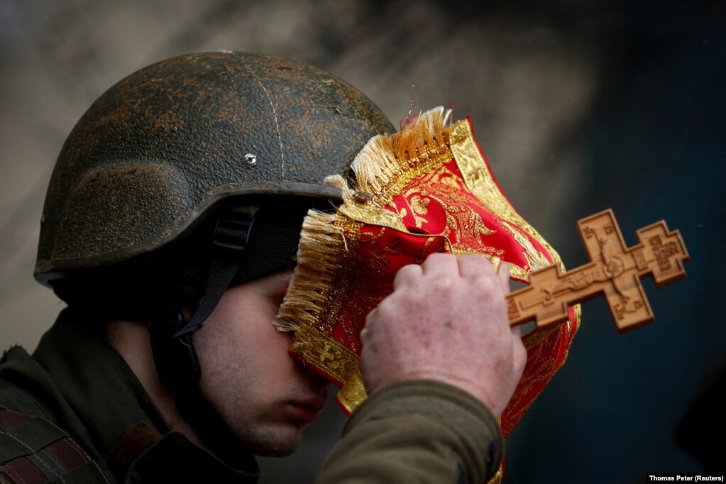 Kapelani ushtarak, Nikolay Medynsky, duke bekuar një ushtar ukrainas, para nisjes së tij për të luftuar. (Kiev, 13 mars)
