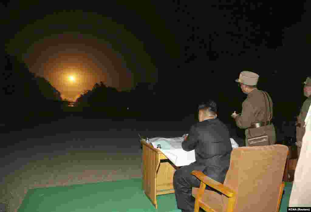 Udhëheqësi koreanoverior, Kim Jong Un, duke shikuar lëshimin e raketave taktike, gjatë manovrave ushtarake. Fotografi e publikuar më 10 korrik 2014.