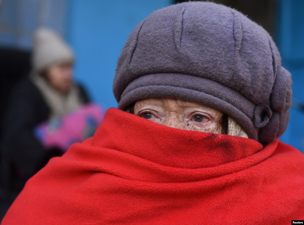 Një qytetare duke qëndruar para një ndërtese banimi. (Mariupol, 19 mars)