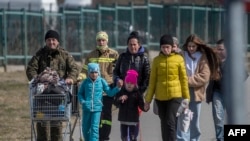 Poljski vojnik pomaže ukrajinskim izbjeglicama da pređu ukrajinsku granicu s Poljskom na graničnom prijelazu Medyka, na jugoistoku Poljske, 27. marta 2022.