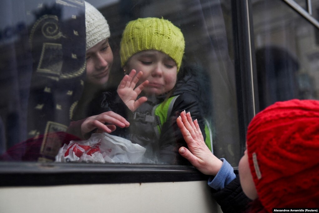 Alexandra, 12-vjeçare, duke mbajtur motrën e saj, Esyean, 6-vjeçare, e cila qante teksa përshëndeste nënën e saj, Irinën, përderisa  pjesëtarët e komunitetit hebraik hipnin në një autobus për të ikur nga lufta e nisur nga Rusia. (Odesë, 7 mars)