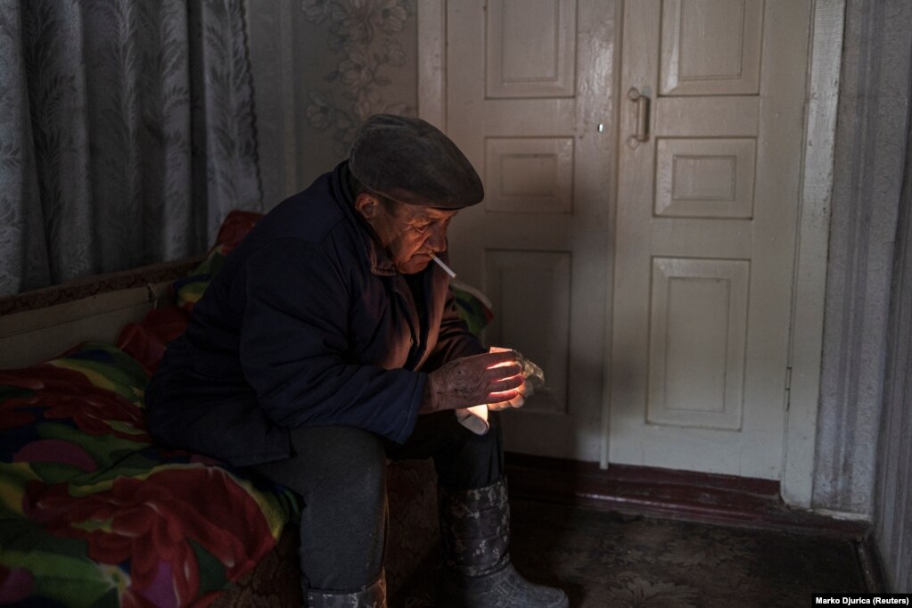 Një burrë duke ndezur një cigare brenda shtëpisë së tij të dëmtuar, ndërkohë që po vijon sulmi i Rusisë ndaj Ukrainës. (Krasilivka, 26 mars)