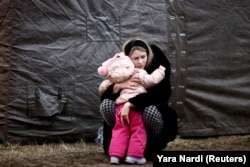 Женщина с ребенков в лагере для беженцев из Украины в Польше