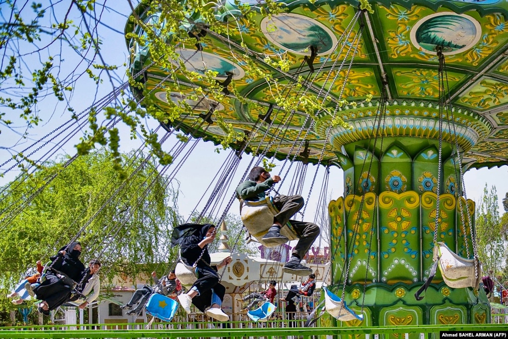 Njerëzit shijojnë lojën me karusel në një park argëtimi në Kabul më 28 mars, pasi Ministria e Talibanëve për Promovimin e Virtytit urdhëroi që të gjitha vendet me kënde lojërash në kryeqytet duhet të ndahen sipas gjinisë.