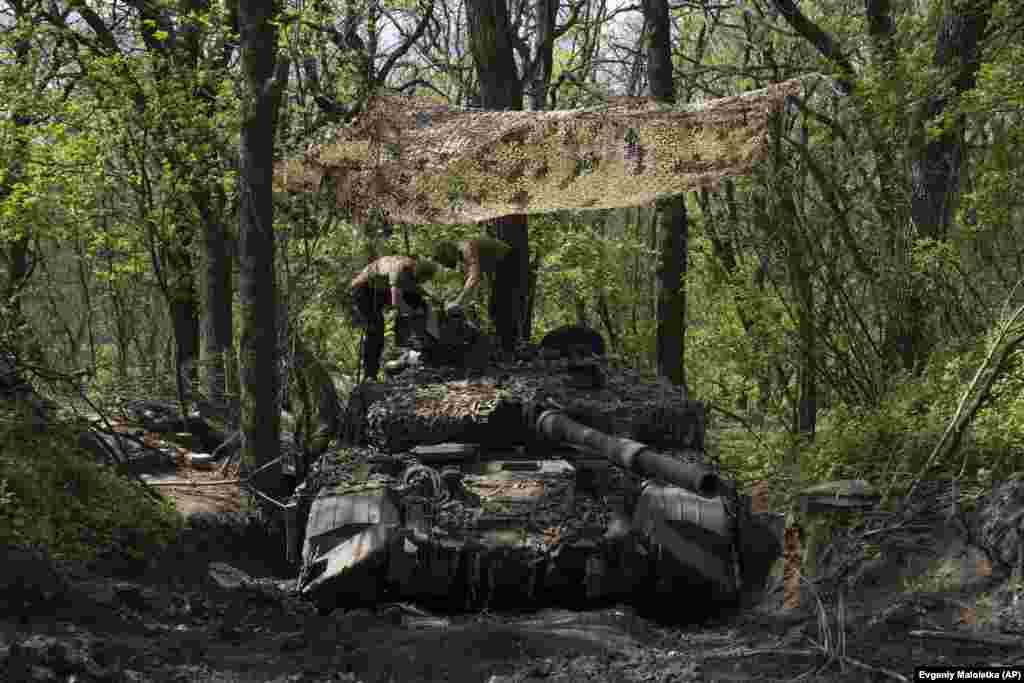 Ukrainian servicemen install a machine gun onto the turret of a tank in the Donetsk region on April 27.&nbsp;