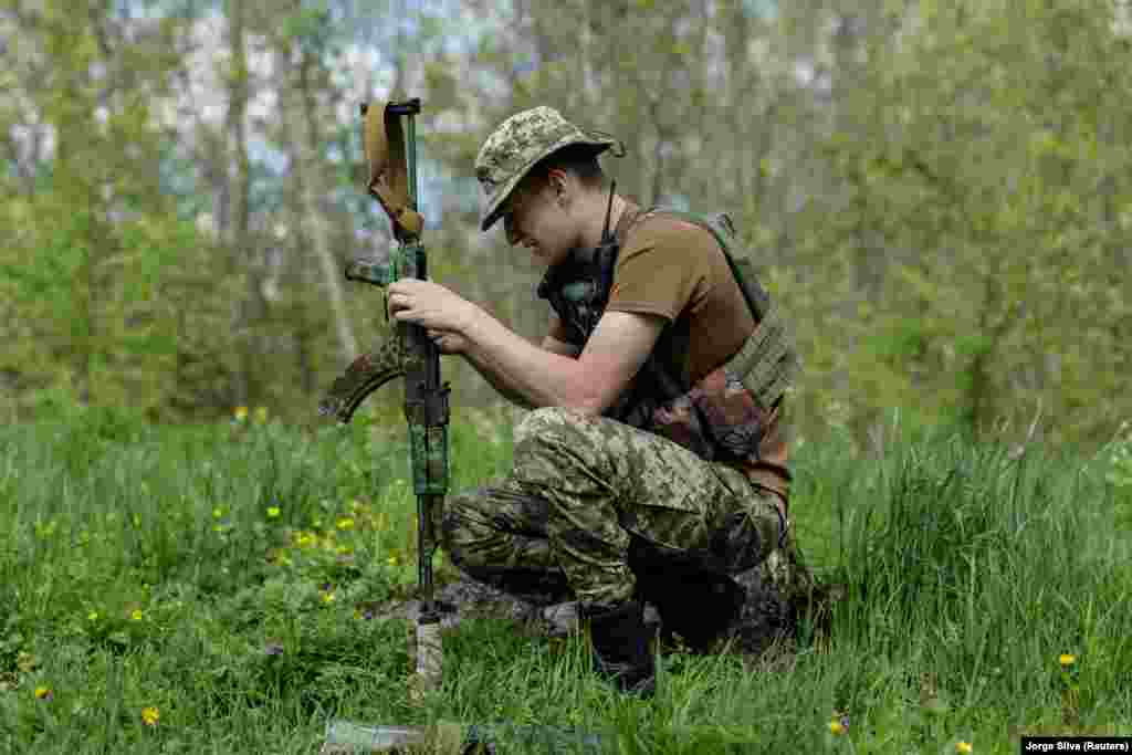 Një luftëtar ukrainas duke pastruar pushkën e tij, afër vijës së frontit, në Sviatohirsk, më 27 prill.