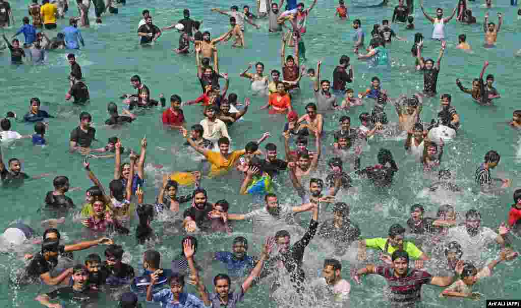 People cool off at a swimming pool during a hot summer day in Lahore, Pakistan.