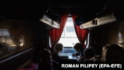 Діти-сироти з окупованого Росією міста Пологи в евакуаційному поїзді у Запоріжжі перед дорогою на захід України. Фото: 26 березня 2022 року