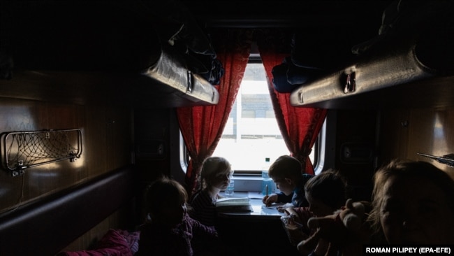 Діти-сироти, які виїхали з окупованого російською армією українського міста Пологи, чекають в евакуаційному поїзді перед виїздом на захід України, на залізничному вокзалі в Запоріжжі, 26 березня 2022 року