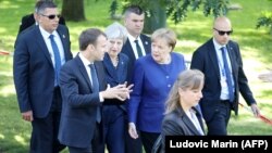 Fransuz prezidenti Emmanuel Makron (çepde), Beýik Britaniýanyň premýer-ministri Tereza Meý (ortada) we nemes kansleri Angela Merkel